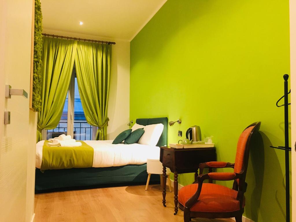 ナポリにあるB&B Grande Archivio Napoliの緑豊かなベッドルーム(ベッド1台、デスク、椅子付)
