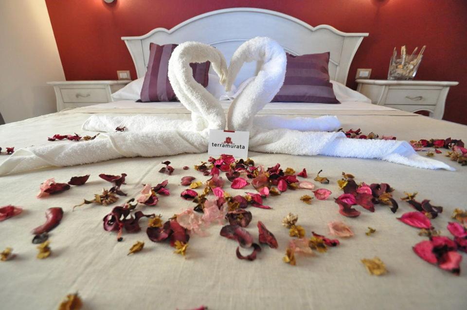 Zwei Schwäne stehen auf einem Bett mit Blumen drauf. in der Unterkunft Terra Murata Boutique b&b in Procida