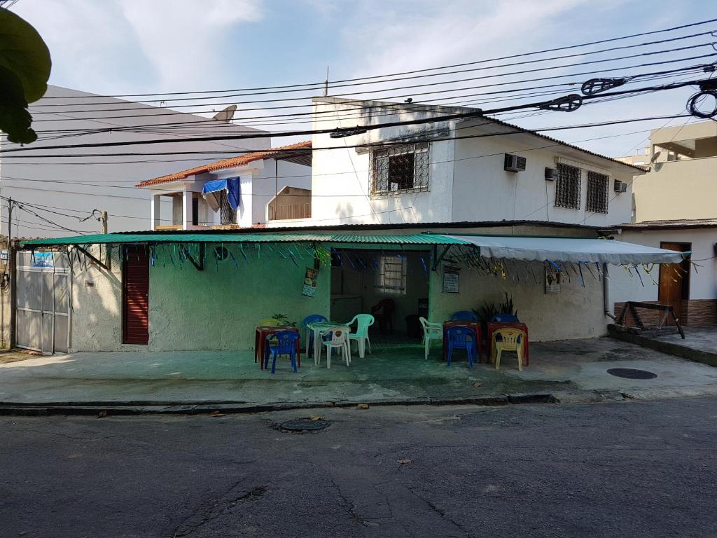 a house with chairs and tables in front of it at Casa na Ilha in Rio de Janeiro