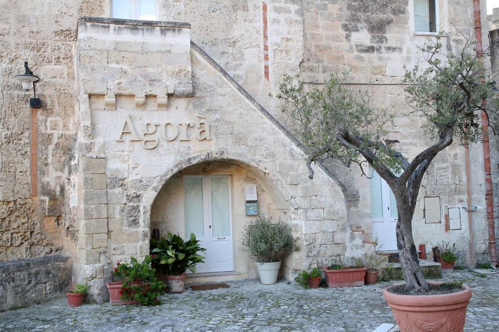 マテーラにあるAgora nei Sassiの植物を取り囲む石造りの建物の入口