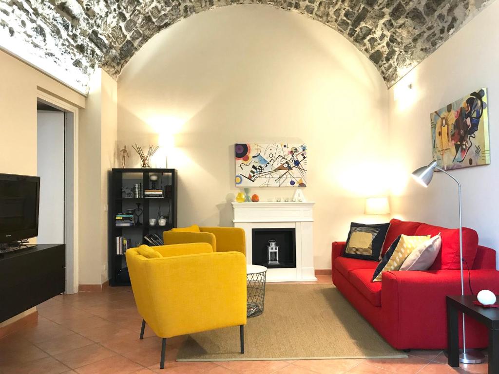 ein Wohnzimmer mit einem roten Sofa und gelben Stühlen in der Unterkunft La Casa di Andrea - by MyHomeInComo in Como