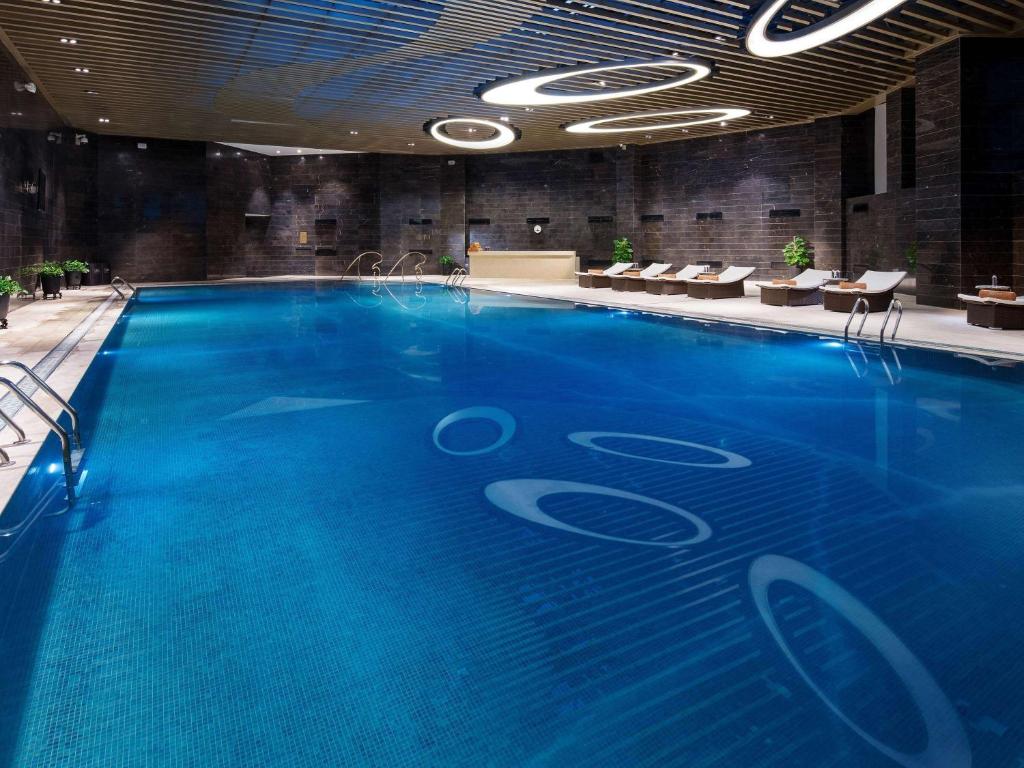 a large blue swimming pool in a building at Sofitel Guiyang Hunter in Guiyang