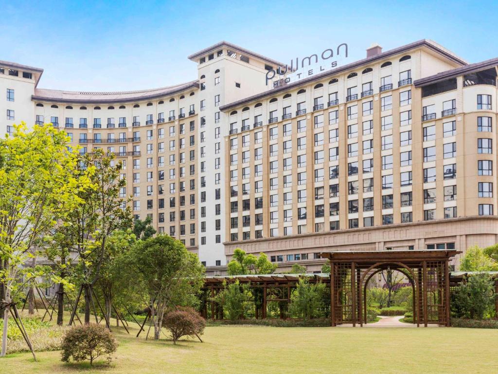 um grande hotel com um arco num parque em Pullman Nanchang Sunac em Nanchang