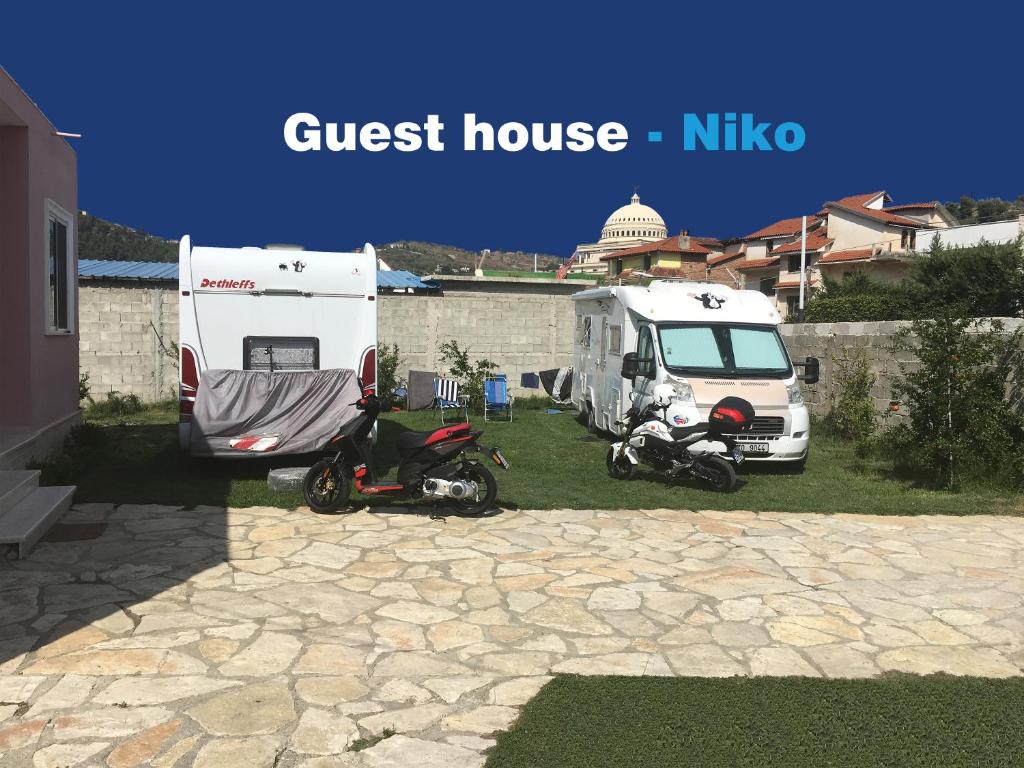 uma scooter estacionada ao lado de uma caravana e de um camião em Guesthouse Niko em Berati