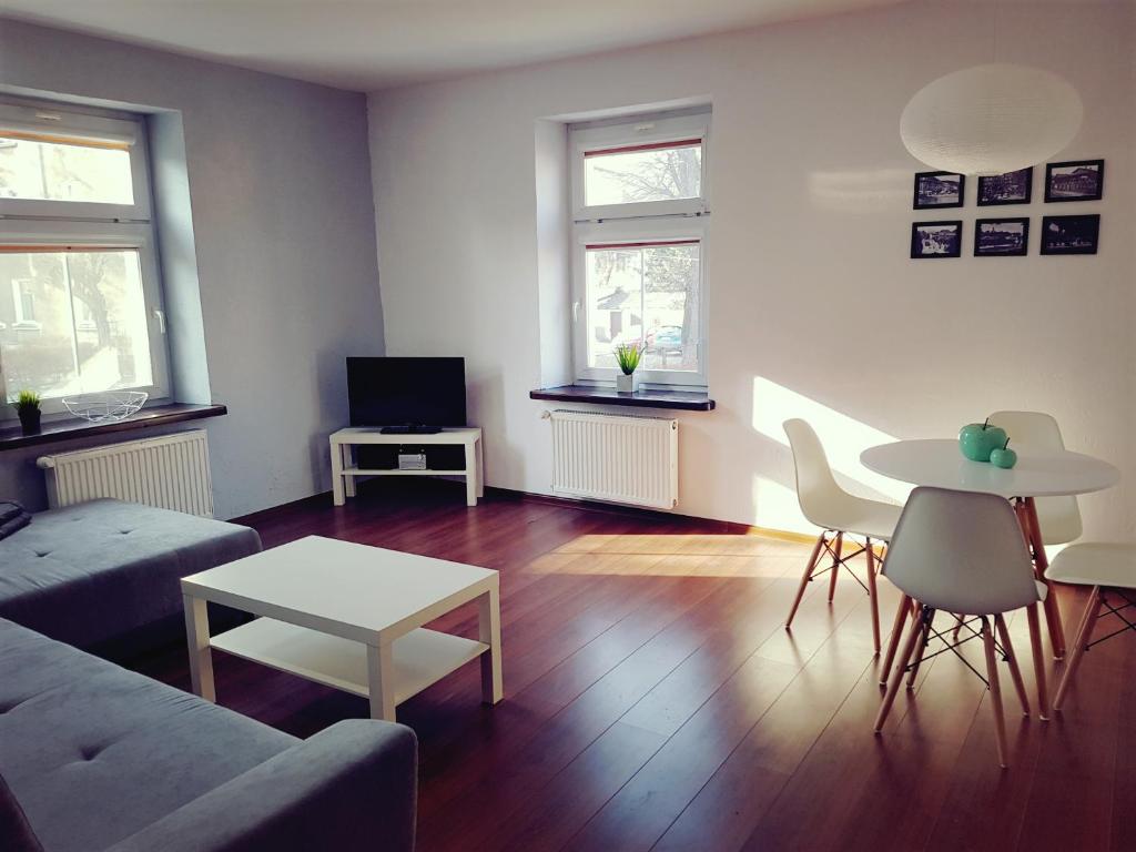 uma sala de estar com um sofá e uma mesa em Apartament Szczawno-Zdrój em Szczawno-Zdrój