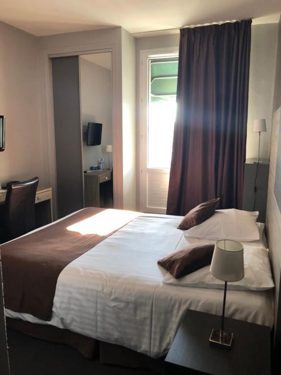 1 dormitorio con 1 cama grande y ventana en Logis - Hôtel du Nord et Restaurant La Table d'Elisa, en Compiègne