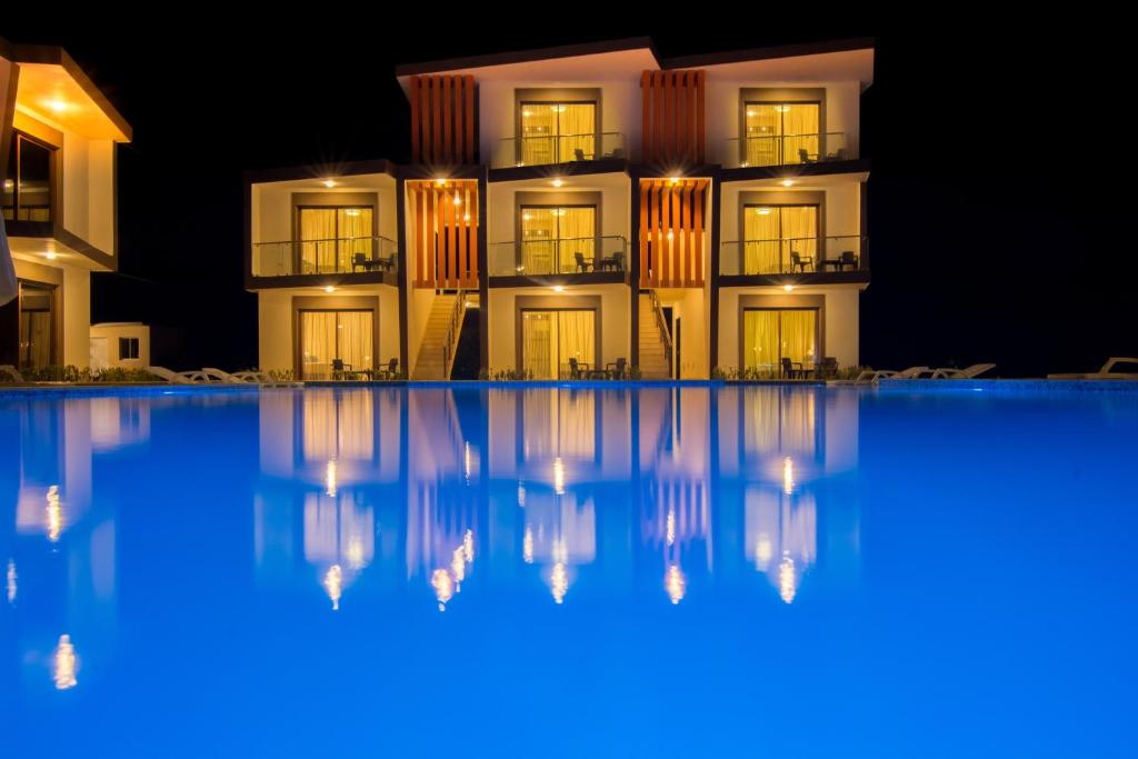 a view of a hotel from the pool at night at Caribbean Diamond Boutique Hotel in Sosúa