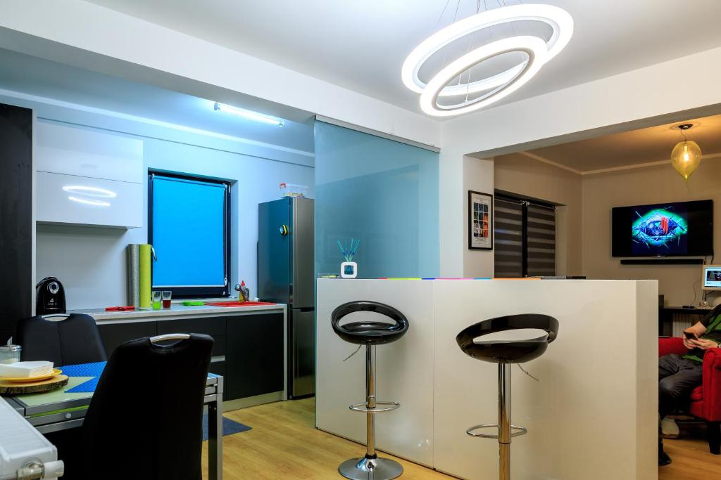 una habitación con dos taburetes y un mostrador con una pared azul en RELAX Cluj Apartment and Terrace, en Cluj-Napoca