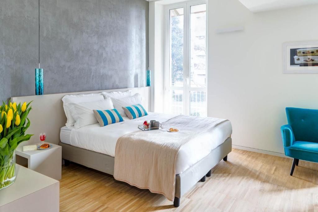 1 dormitorio con 1 cama y 1 silla azul en T7, en Milán
