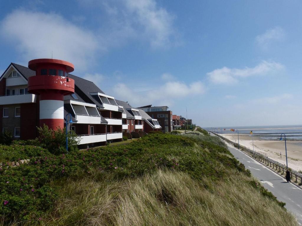 a building with a lighthouse on the side of a beach at Haus Leitfeuer Whg. 19 in Wittdün