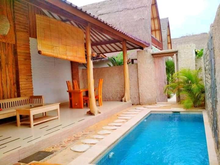 a swimming pool on the patio of a house at Villa Rika in Gili Trawangan