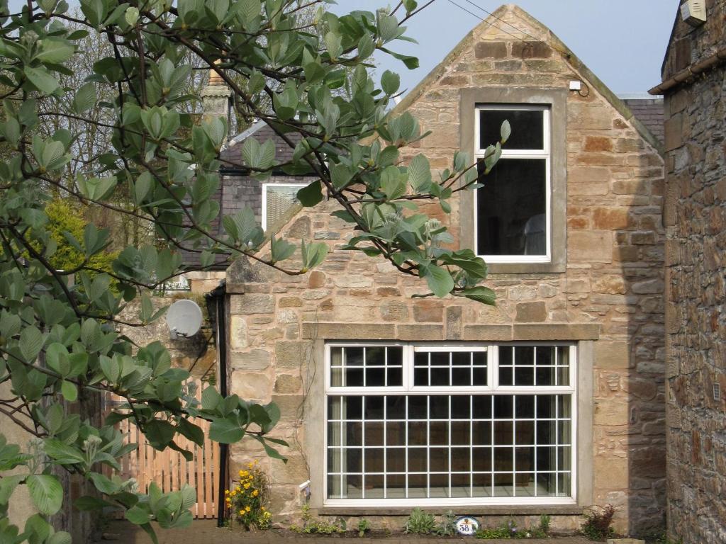エアにあるDairy Cottageの窓と柵のある石造りの家
