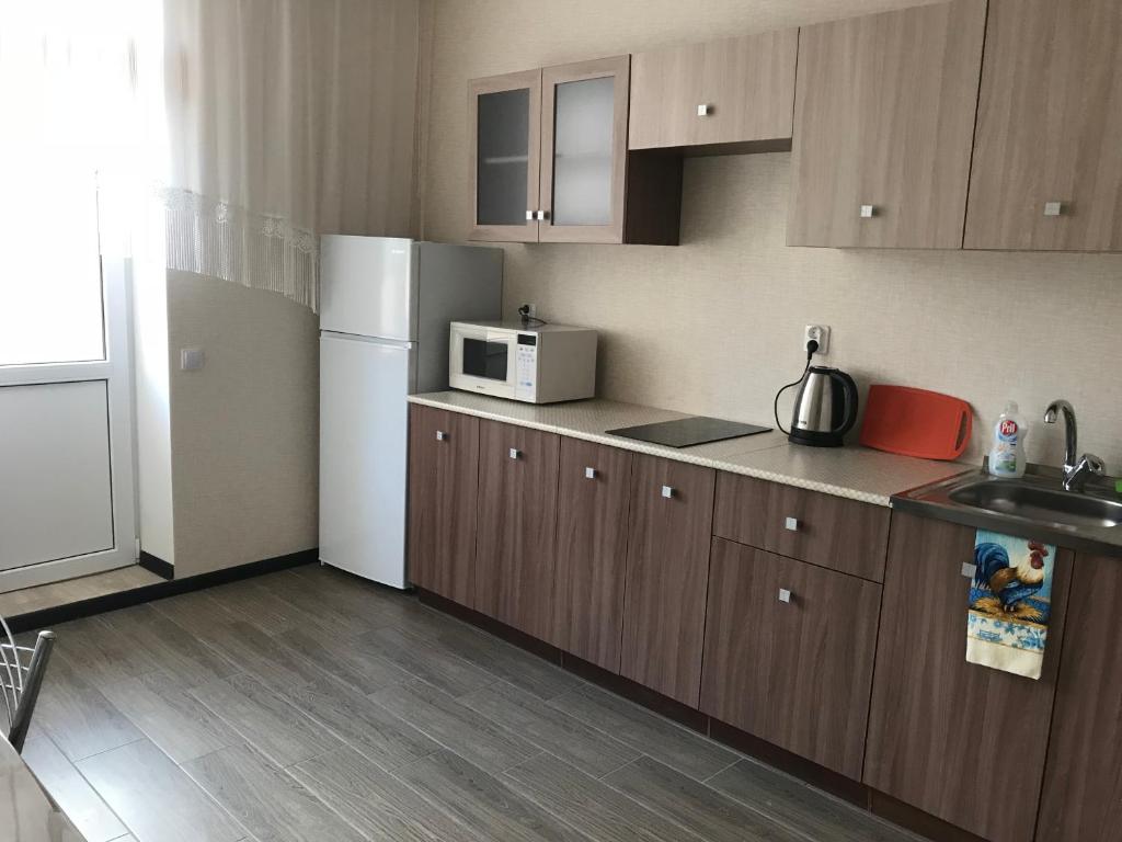 a kitchen with a white refrigerator and a microwave at Apartments of PANORAMA Krasnodar in Krasnodar