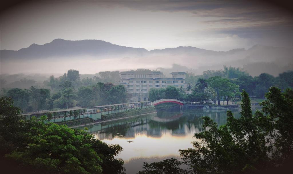 un puente sobre un río con un edificio al fondo en 柳營尖山埤 Liuying Jianshanpi Resort, en Liuying