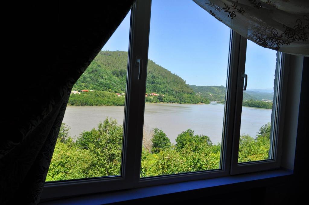 een raam met uitzicht op een rivier bij Nature House in Koetaisi