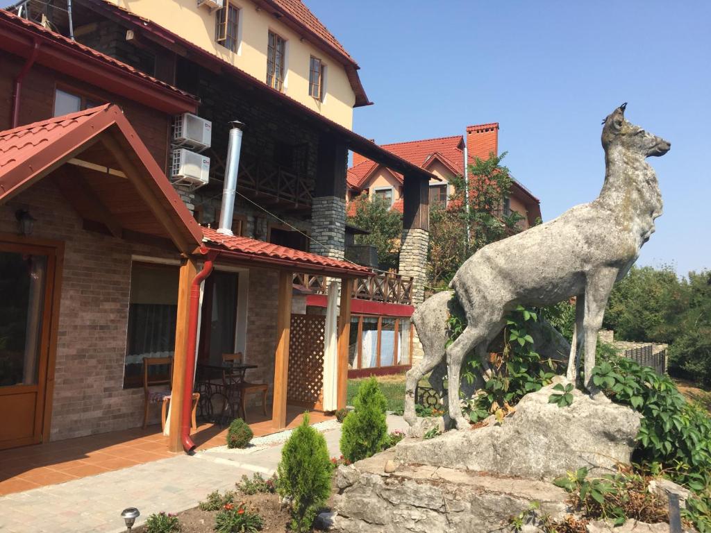 una estatua de un caballo sobre una roca delante de una casa en Guesthouse Grand Canyon, en Kamianets-Podilskyi