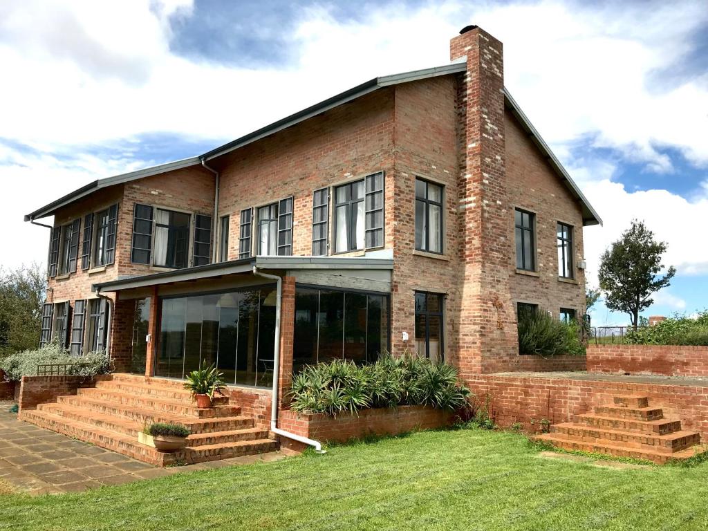 an old brick house with a large window at Mission House in Howick