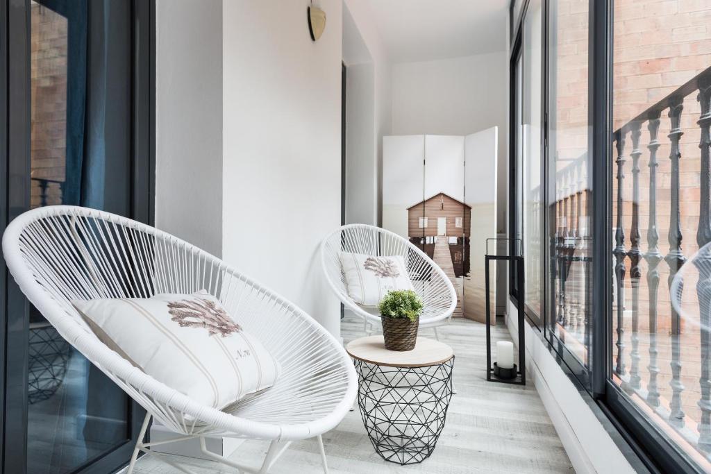 una fila de sillas blancas en un balcón en Stay U-nique Apartments Rossello, en Barcelona