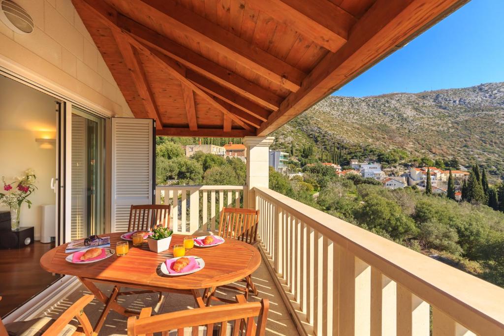 uma mesa de madeira numa varanda com uma mesa e cadeiras em Apartment Zaton em Zaton