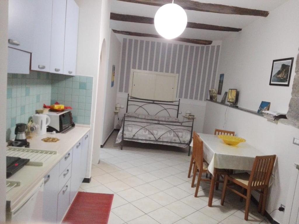 a kitchen with a table and a room with a bed at Sunset House in Riomaggiore