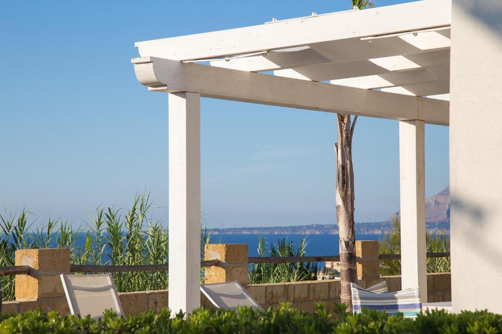 a group of chairs sitting under a pergola at Petruso Resort in Balestrate