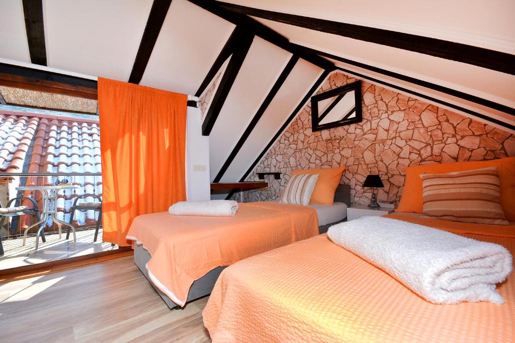 a bedroom with two beds and a large window at Apartments & Rooms As in Vis