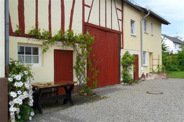 GondershausenにあるZur alten Schreinereiの赤いドアと前のベンチのある家