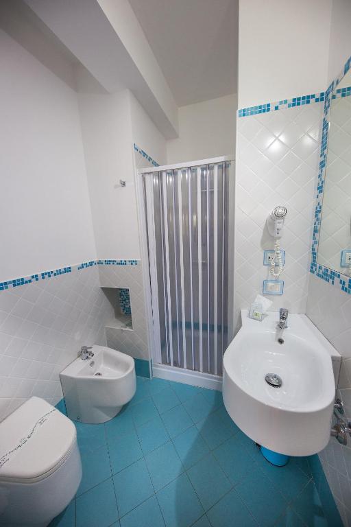 a blue and white bathroom with a toilet and a sink at Petruso Resort in Balestrate