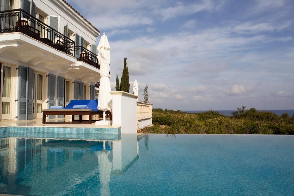 a villa with a swimming pool in front of a building at Anassa in Polis Chrysochous