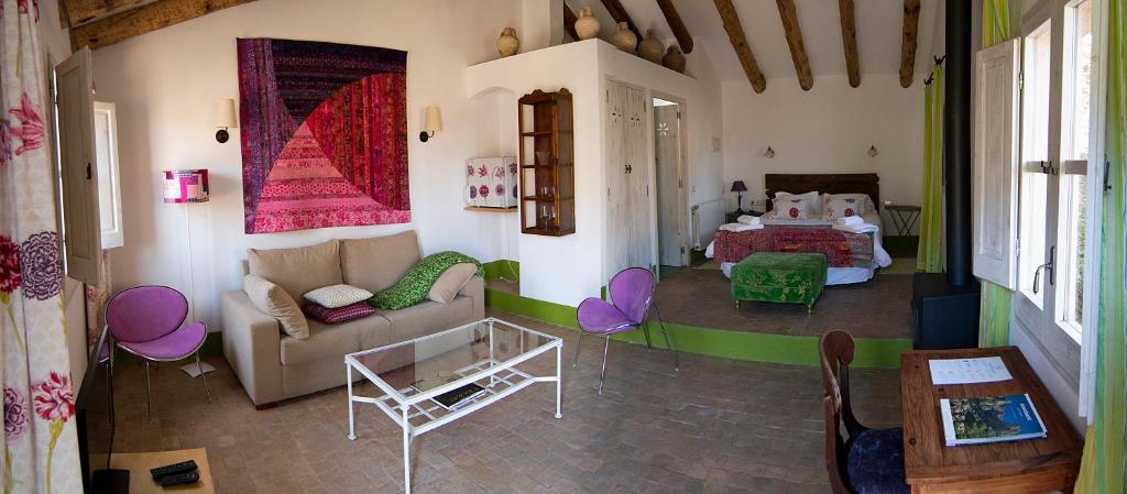 ein Wohnzimmer mit einem Sofa und einem Bett in der Unterkunft Mas Ardevol PT106 in Porrera