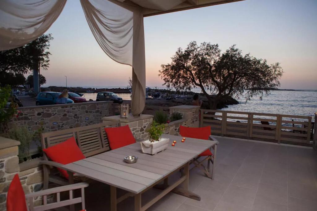 a table and chairs on a patio overlooking the water at On the water lodging 1 in Falasarna