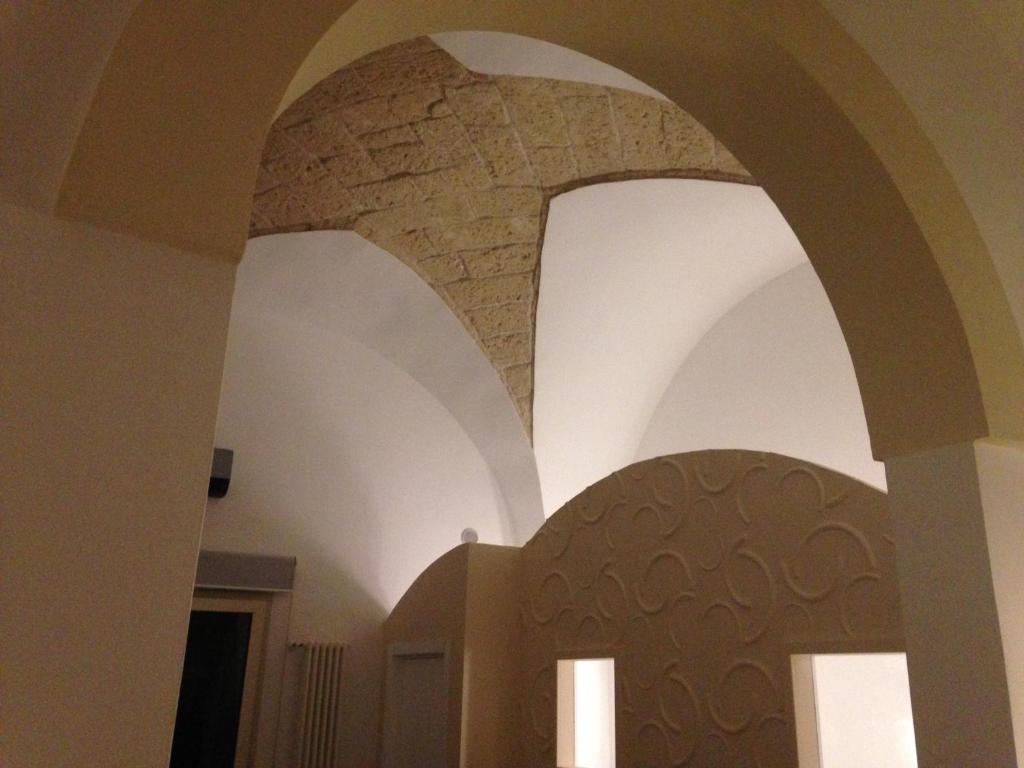 Miklù Luxury Suite في ليتشي: ممر في مبنى به جدار حجري