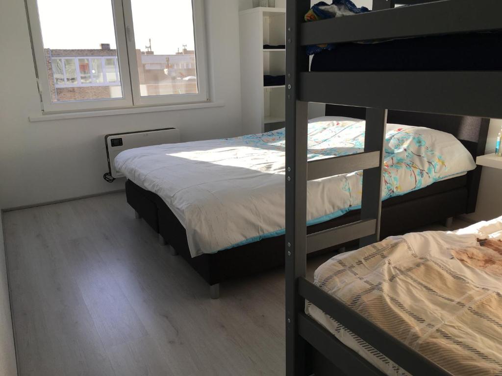 a bedroom with two bunk beds and a window at Appartement Thea in Middelkerke