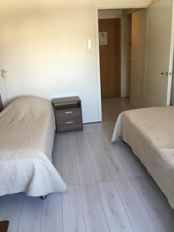 dos camas sentadas una al lado de la otra en un dormitorio en Leo Hotelli, en Kouvola