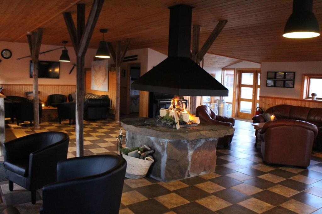 a living room with a fireplace in the middle of a room at Hótel Á in Reykholt