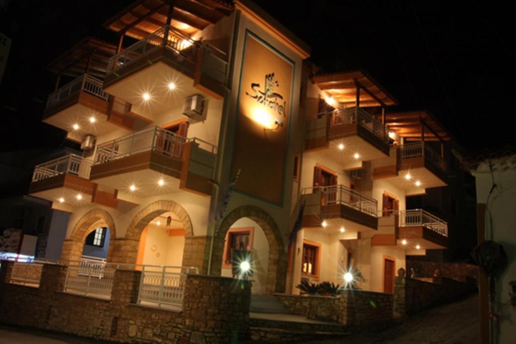 a building with a clock on the side of it at night at Sofotel in Koroni