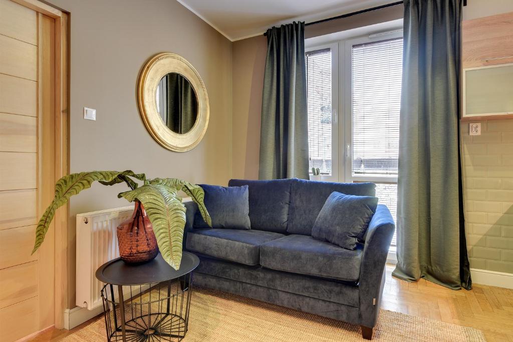 a living room with a blue couch and a table at Lion Apartments MEWA in Sopot