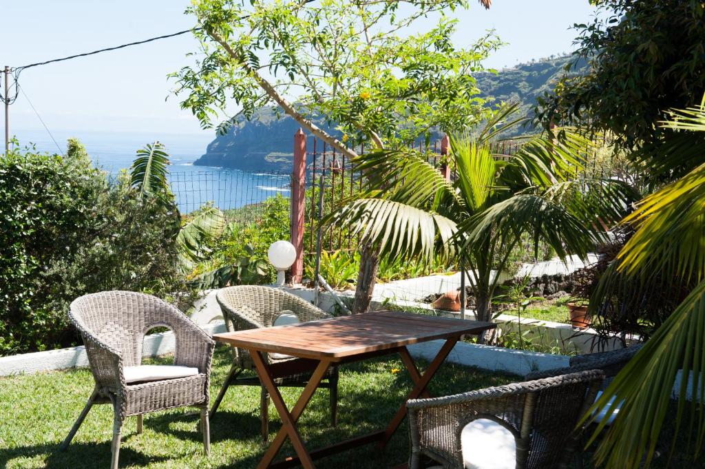 ラ・オロタバにあるFinca Los Pajaresの海の景色を望む芝生の上にテーブルと椅子