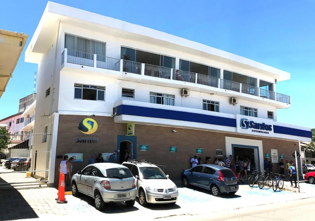 a building with cars parked in front of it at Hotel Pousada Santos in Pinheira