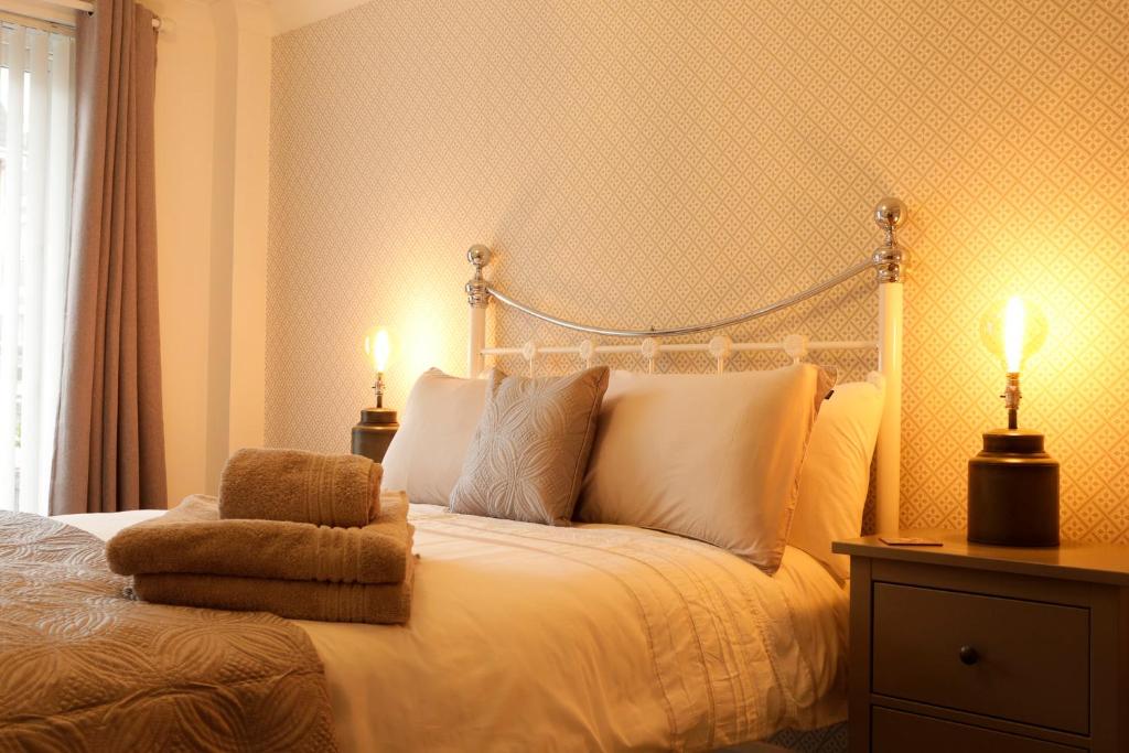 a bedroom with a white bed with two lamps at Newly refurbished 1 bed first floor apartment with wifi in Cosham