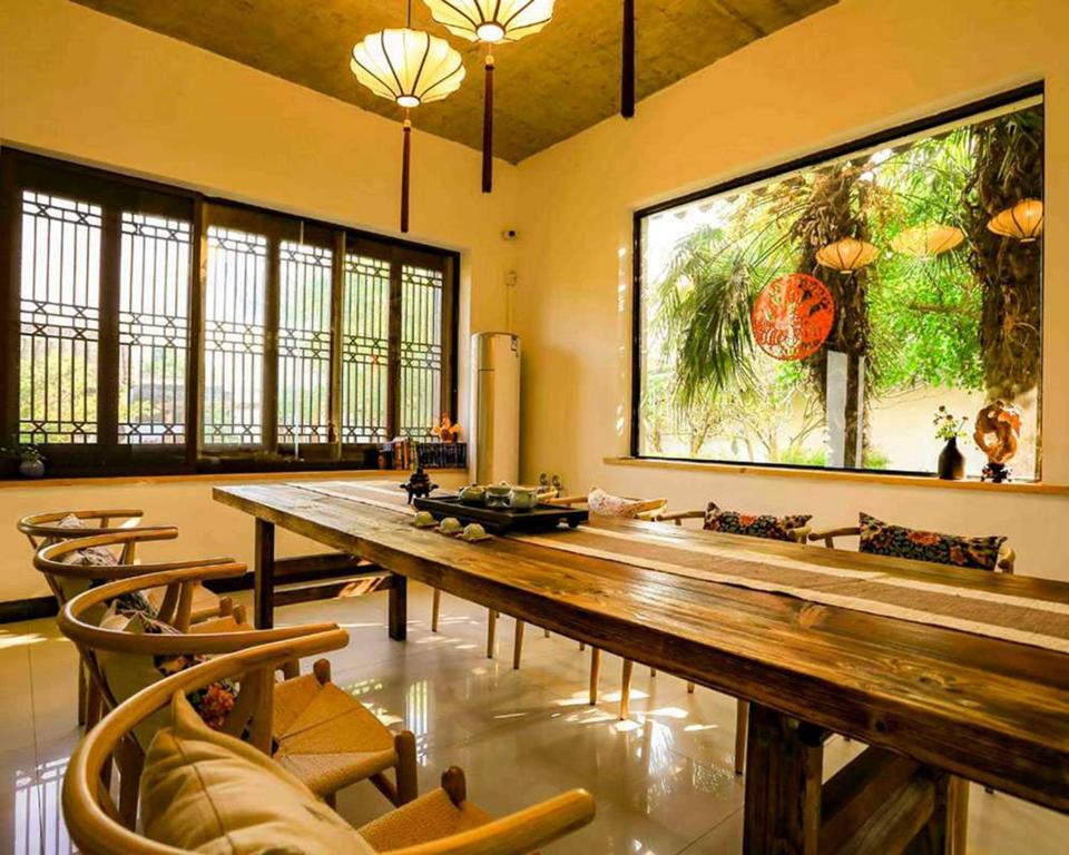 um quarto amplo com uma longa mesa e cadeiras de madeira em Pure-Land Villa em Suzhou