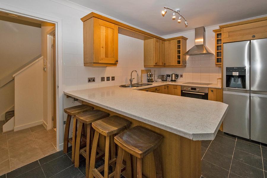 a kitchen with a large island with bar stools at 37A Commerce Street in Lossiemouth