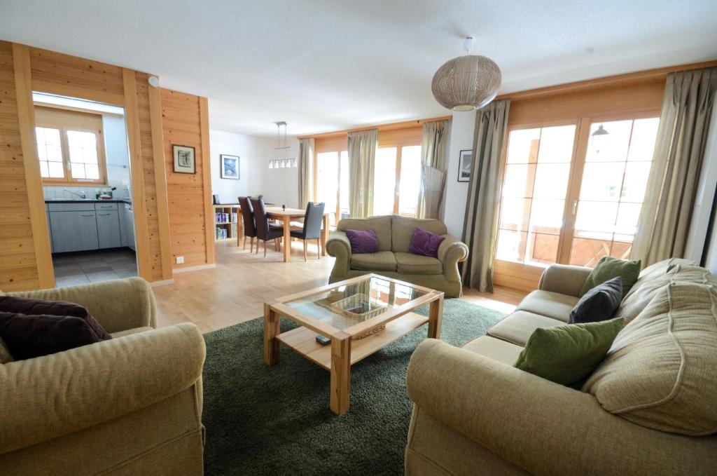 a living room with two couches and a table at Luxury Family Apartment in Lauterbrunnen