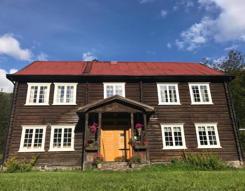 una antigua casa de madera con techo rojo en Sevletunet B&B and Cabins en Rødberg