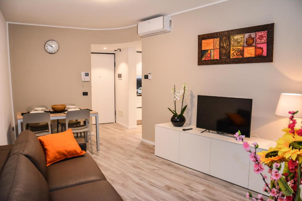 ein Wohnzimmer mit einem Sofa und einem Flachbild-TV in der Unterkunft Rivacentro in Riva del Garda