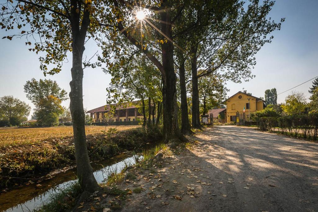 a tree lined road with a house in the background at Cascina Gaggioli in Milan