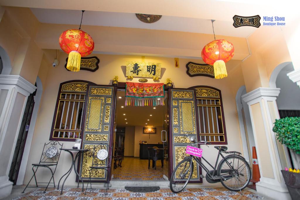 een fiets geparkeerd voor een gebouw met Chinese deuren bij Ming Shou Boutique House in Phuket