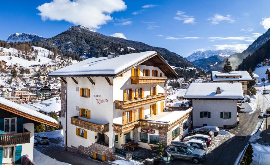 an aerial view of a hotel with snow covered mountains at Garni Rives in Ortisei