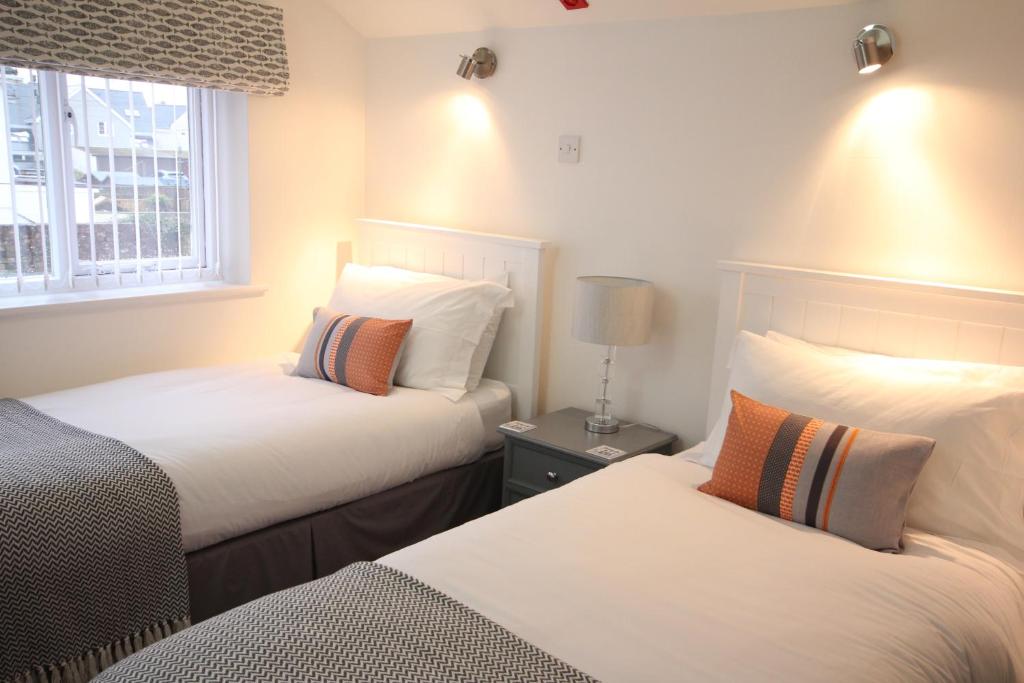 a bedroom with two beds and a window at Berwick House in Sidmouth