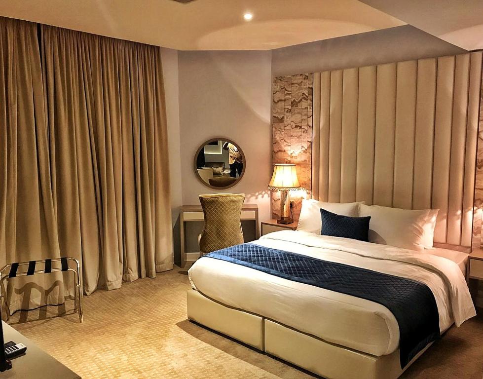 a bedroom with a large bed and a mirror at Lumiere Des Etoile in Kuwait